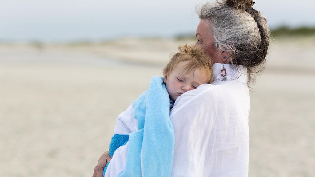 Lapsi nukkuu mummin sylissä