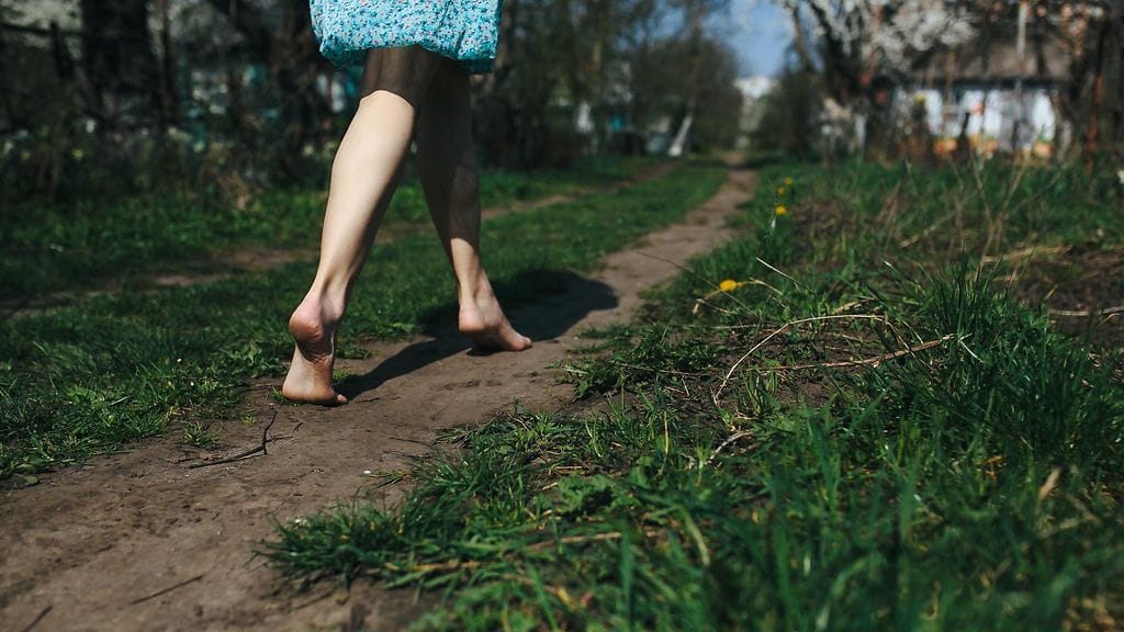 Nainen kävelee paljain jalon