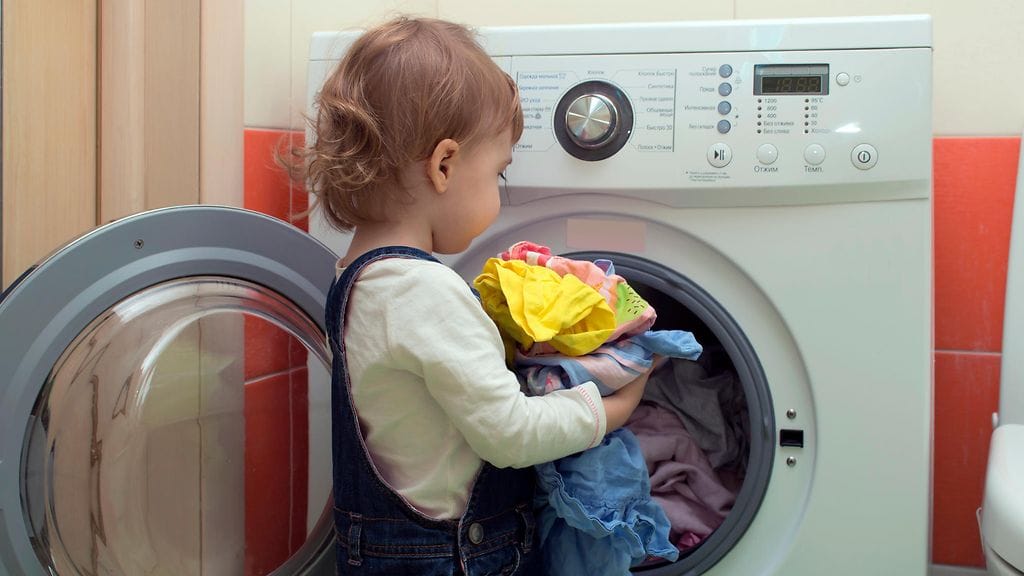 Pienikin lapsi voi auttaa panemaan pyykit koneeseen.