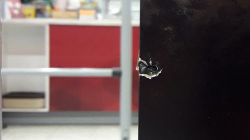 Luoti lävisti kaupan mainostauluja. Poliisin kuva.