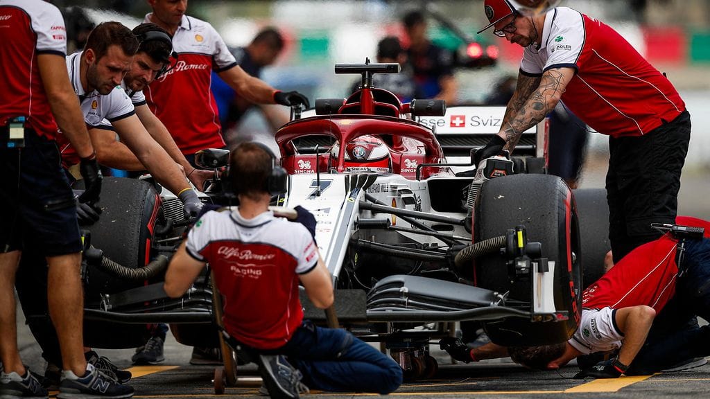 Alfa Romeon mekaanikot Kimi Räikkösen auton kimpussa Suzukassa.