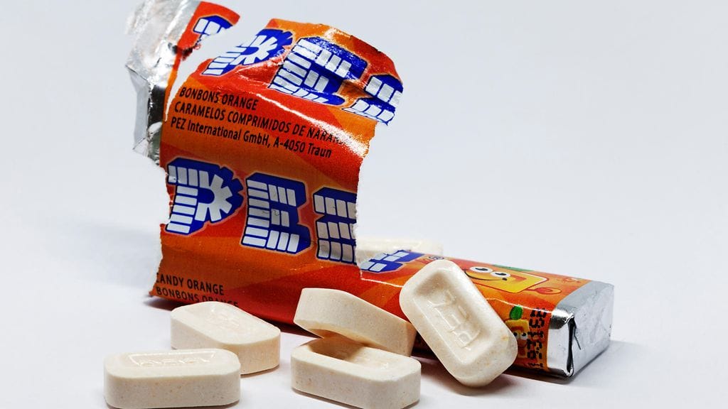 Videolla Pez-karkkipakkaus työnnetään karkkiannostelijaan alapuolelta.