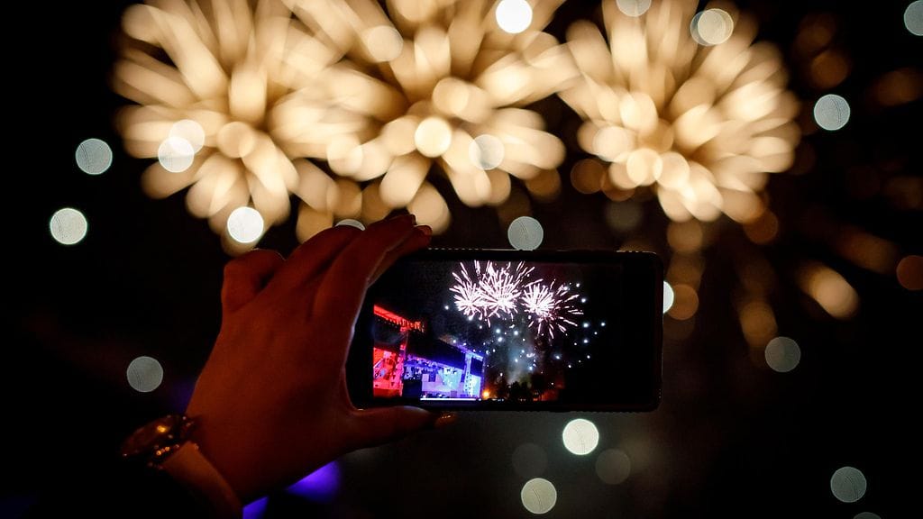 joku kuvaa ilotulitusta puhelimella