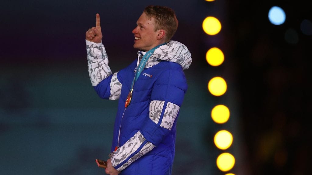 Iivo Niskanen tuulettamassa kultamitalia Pyeongchangin olympialaisten palkintokorokkeella helmikuussa 2018.