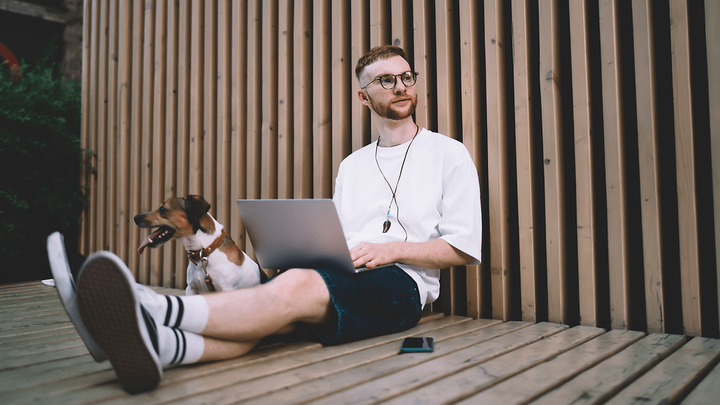 mies istuu jalat ristissä, nilkat