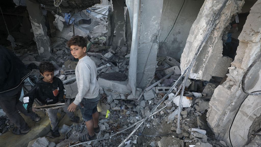 Kaksi lasta kulki pommituksissa sortuneen talon raunioissa Gazassa 19. joulukuuta 2023.