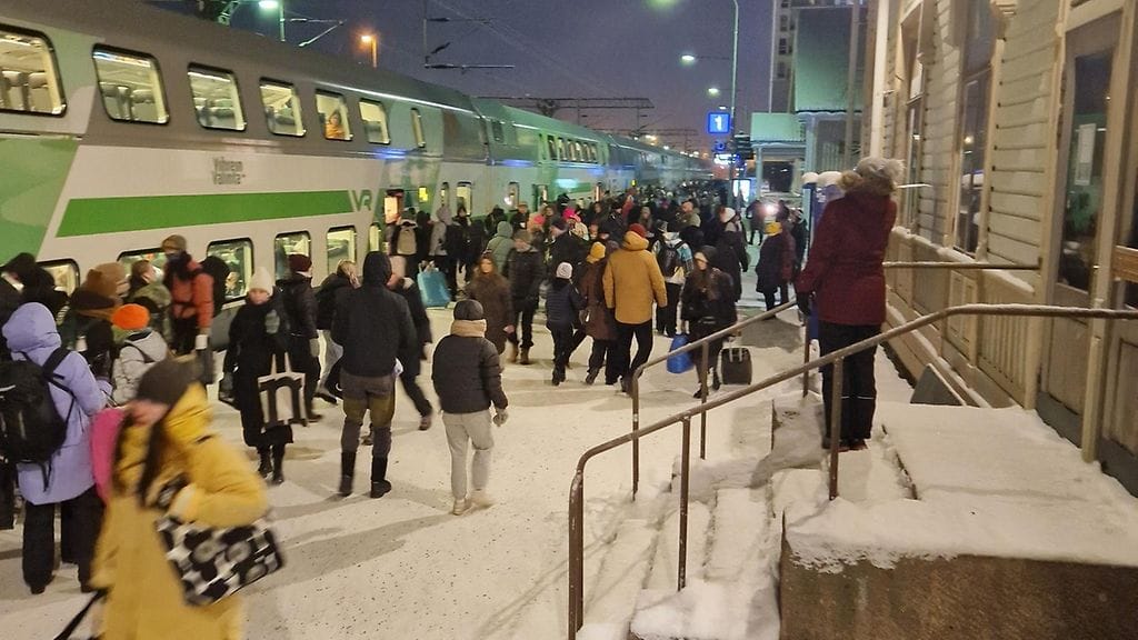 Katja Puhalaisen ottamassa kuvassa ihmiset ovat tunkemassa loppuunmyytyyn junaan Oulun rautatieasemalla tiistaina.