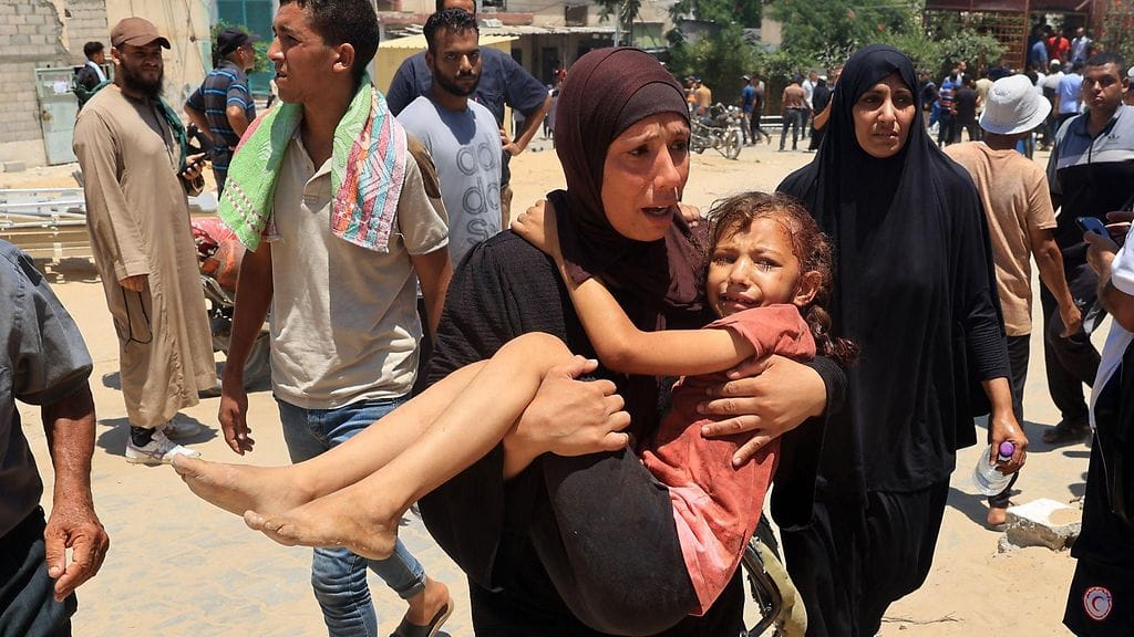 Palestiinalainen nainen kantoi haavoittunutta lasta lauantaina 13. heinäkuuta.