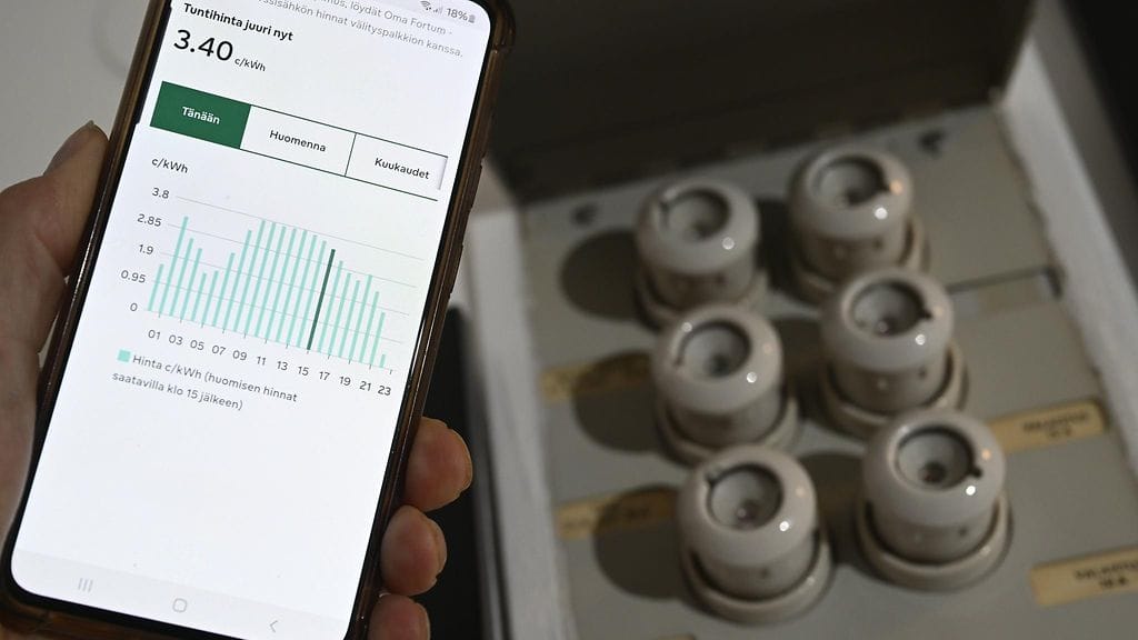Kodin sulaketaulu ja pörssisähkön hinta matkapuhelimen näytöllä Espoossa 14. maaliskuuta.