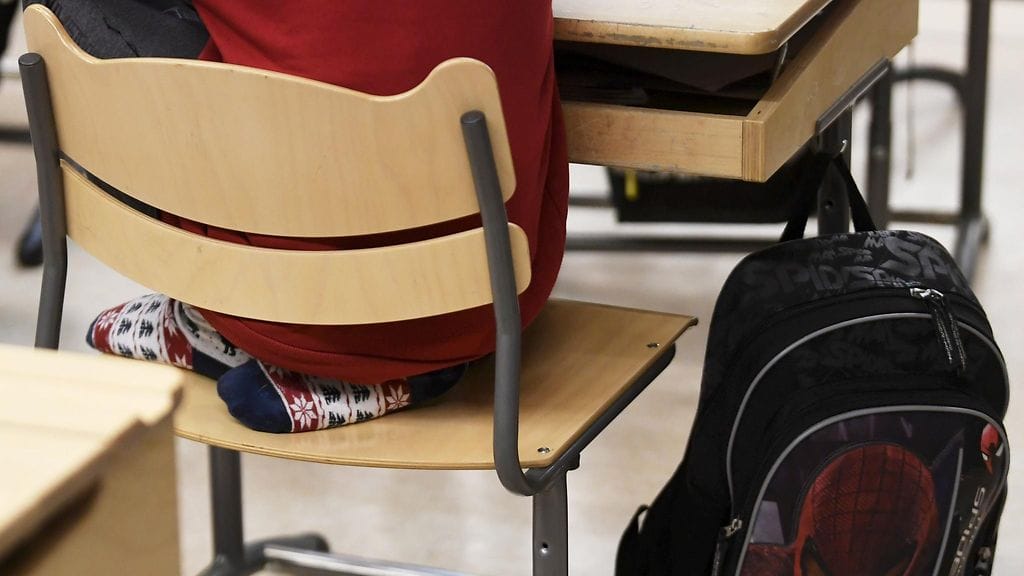 Koululainen luokkahuoneessa oppitunnilla. Kuvituskuva.