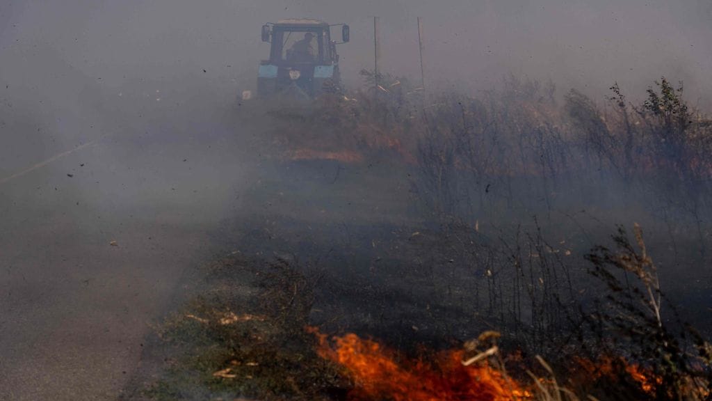 Ukrainalainen maanviljelijä yritti sammuttaa palavaa peltoa lähellä Pokrovskia Donetskin alueella 16. viime kuuta.