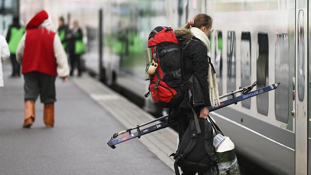 LK 20.12.2024 Matkustaja suksien kanssa astumassa junaan Rautatieasemalla Helsingissä 20. joulukuuta 2024.