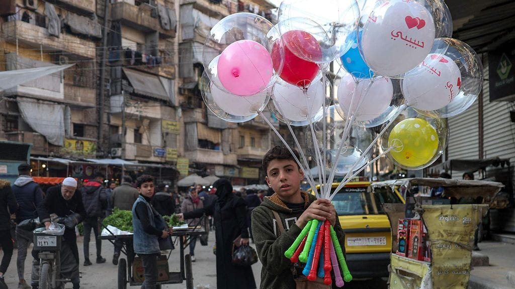 Poika myi ilmapalloja kadulla Syyrian pohjoisessa Aleppon kaupungissa muslimien pyhän paastokuukauden Ramadanin ensimmäisenä päivänä 1. maaliskuuta.