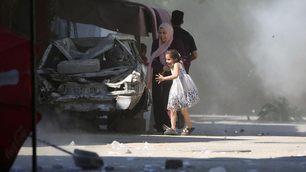 Äiti tyttärineen etsii suojaa Israelin iskulta Bureijin pakolaisleirillä Gazassa 4. heinäkuuta 2025.