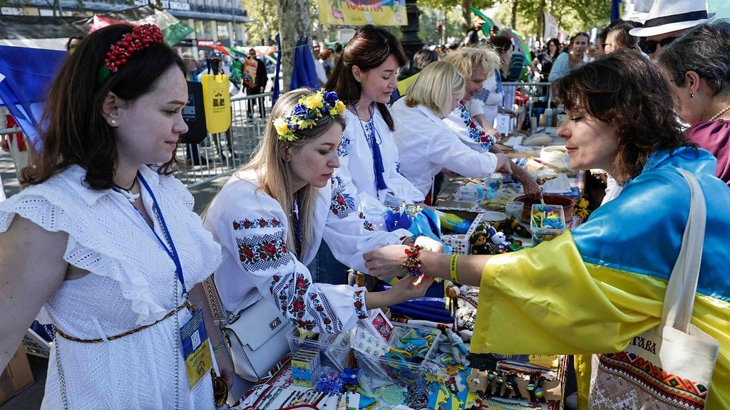 LK 24.8.2025 Nainen kokeilee myynnissä olevaa ukrainalaista rannekorua Ukrainan itsenäisyyspäivän tukitapahtumassa Pariisissa 24. elokuuta 2025.