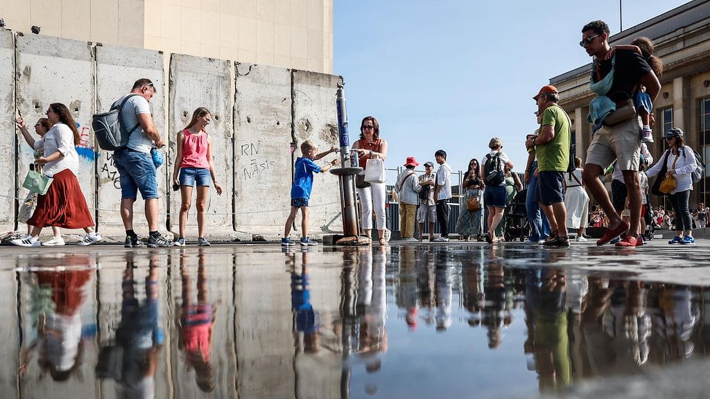 Ihmiset helpottivat oloaan juomavesiautomaatin äärellä Pariisissa Ranskassa 10. elokuuta.