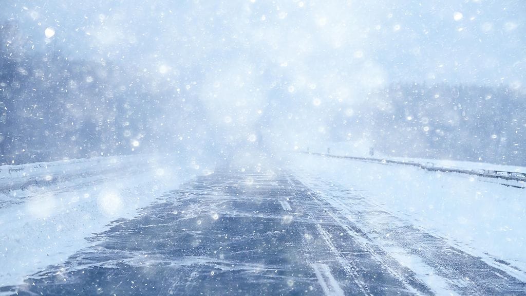 Kuvituskuva maantiestä lumisateessa.