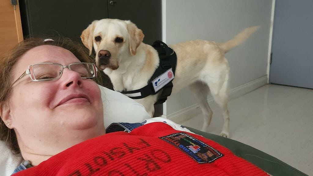 Kipupotilas Kia Konttila Ortonilla yhdessä kipukoira Creman kanssa.