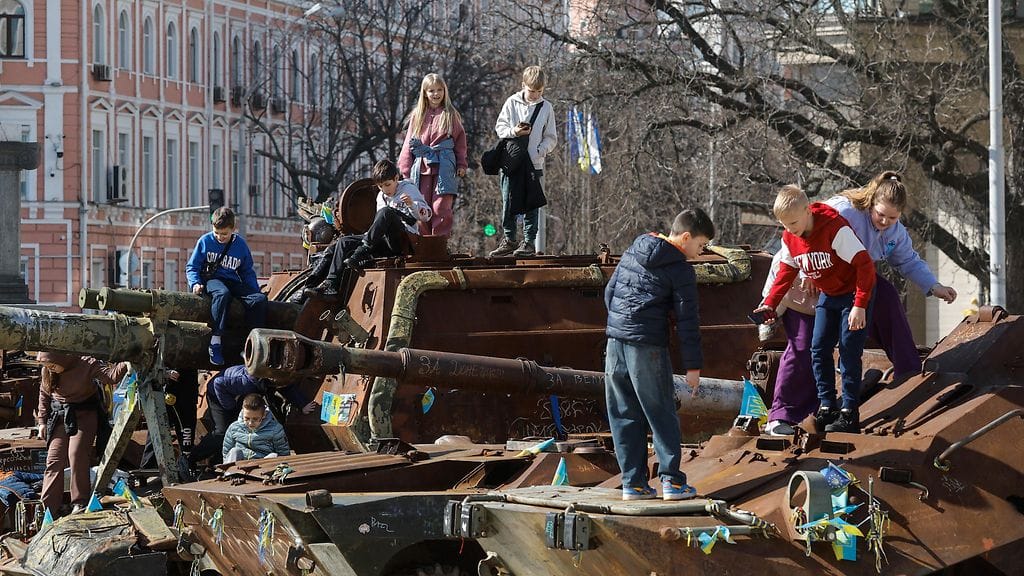 Lapset leikkivät vaurioituneilla taisteluajoneuvoilla osana tuhotun venäläisen sotilaskaluston näyttelyä Kiovassa, Ukrainassa, 20. maaliskuuta 2026.